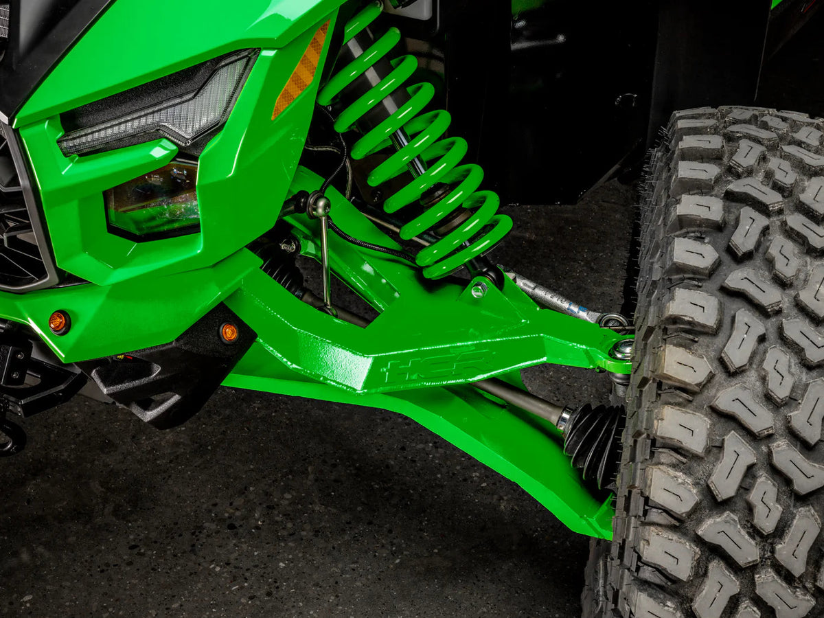 Close-up of a green off-road vehicle suspension system with a tire.